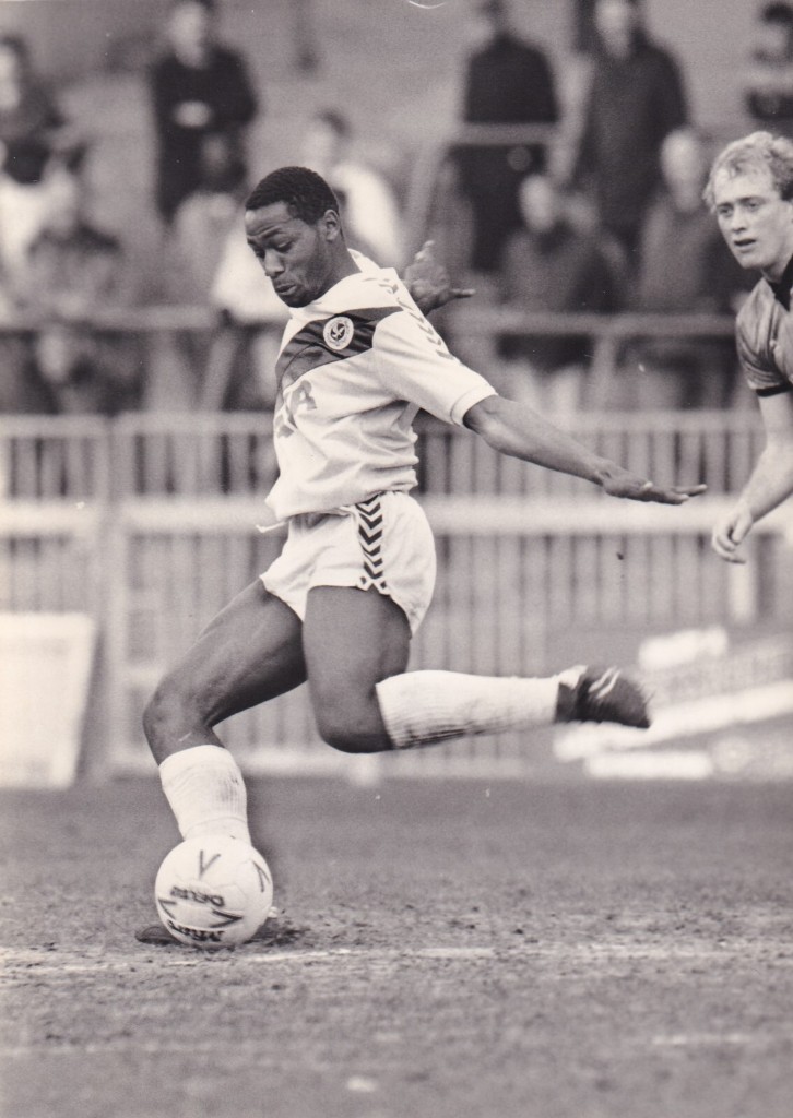 Black-and-white press photo of a Crystal Palace player striking the ball, in the same pose as the box art.